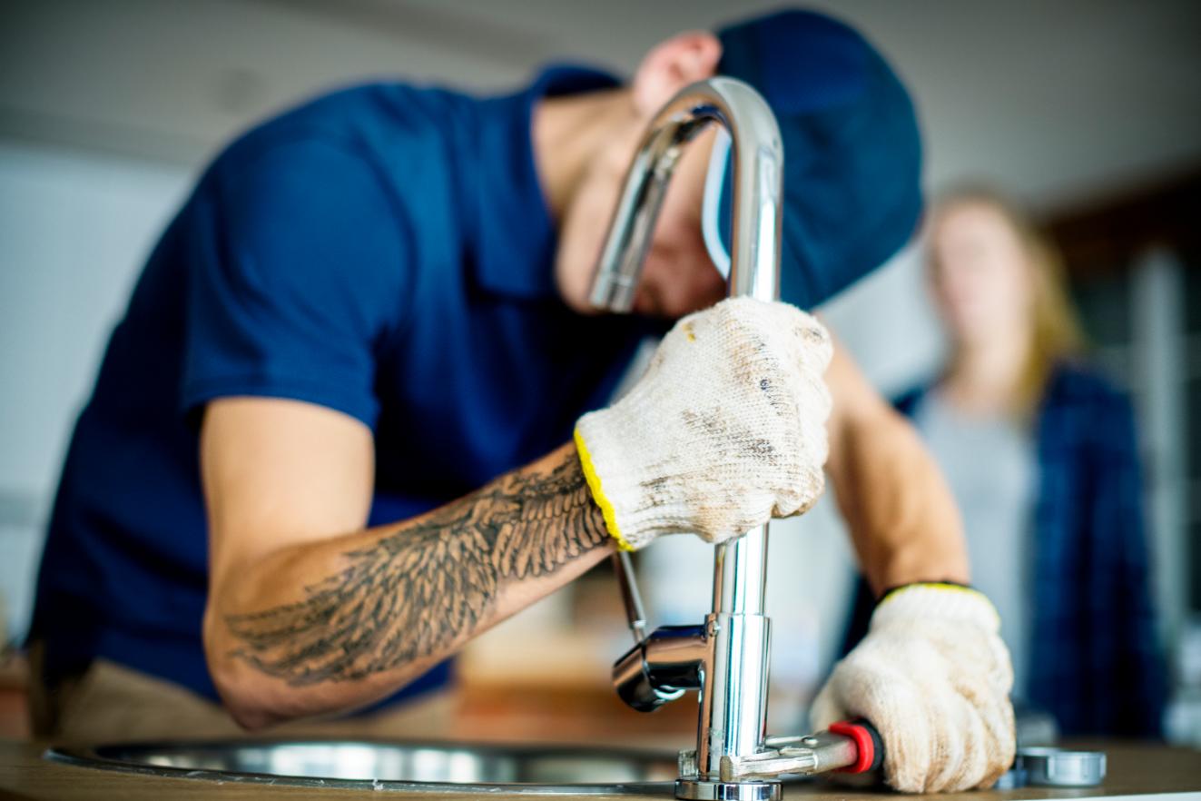 Professional plumber performing detailed sink repair work with precision