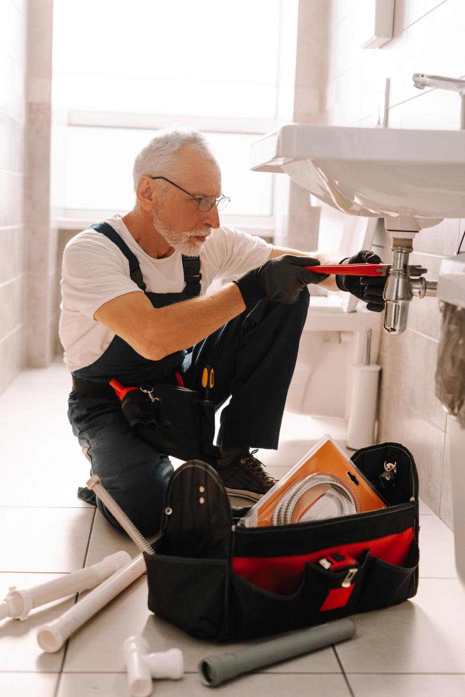 Senior plumber performing professional installation work